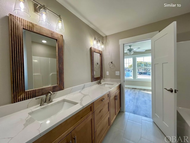 full bathroom with ceiling fan, double vanity, a sink, and tile patterned floors