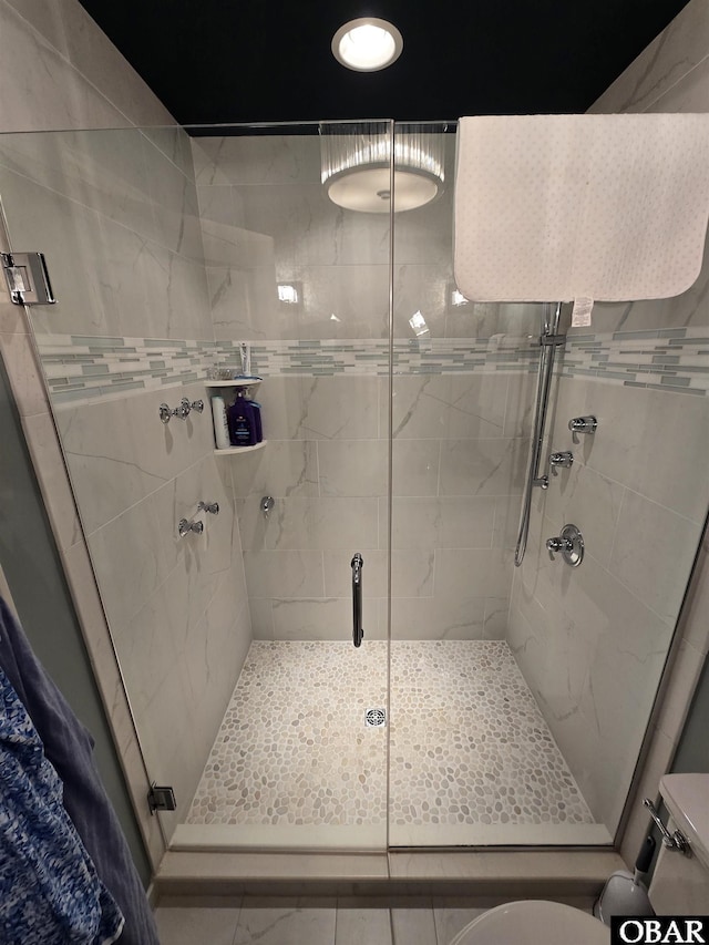 bathroom with a shower stall and toilet