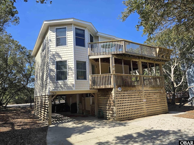 view of front of property with a carport, concrete driveway, and a wooden deck