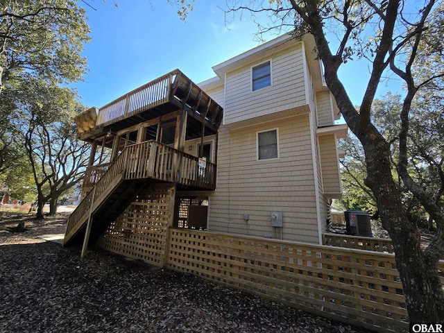 rear view of property with stairway and a wooden deck