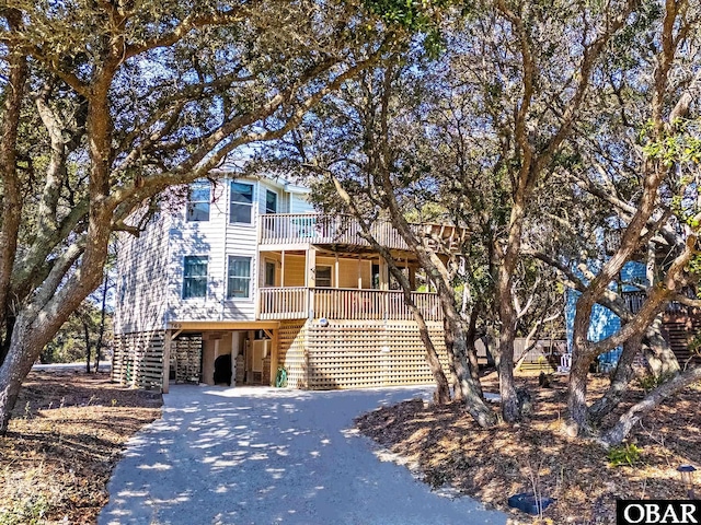 view of front of house featuring driveway, stairway, and a carport