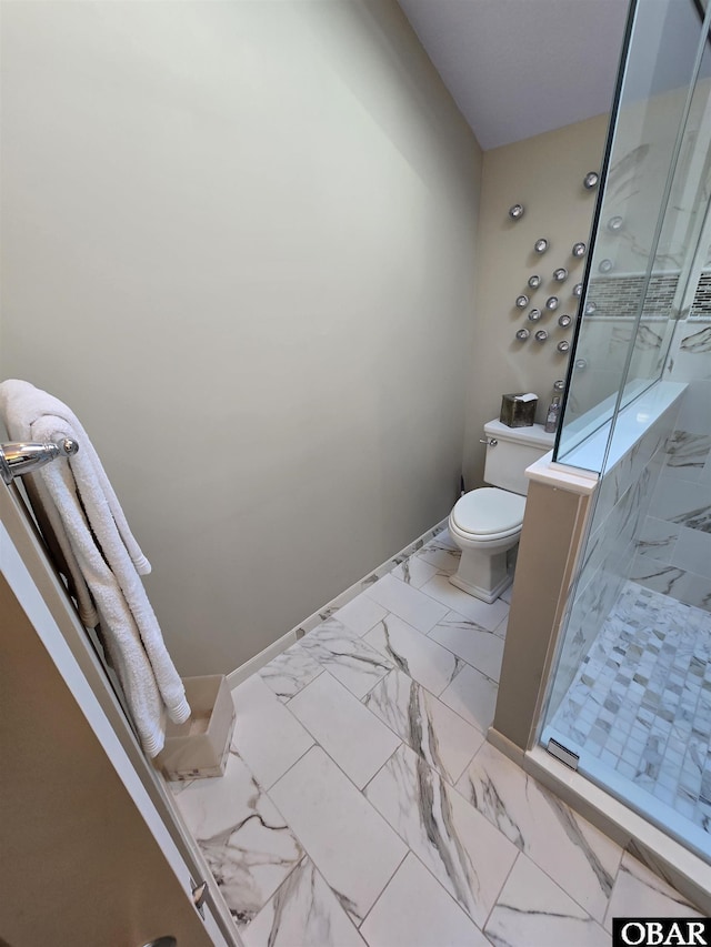 bathroom with toilet, marble finish floor, a shower stall, and baseboards