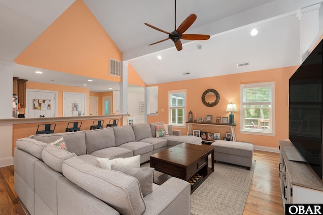 living room featuring light wood-style floors, a ceiling fan, and visible vents