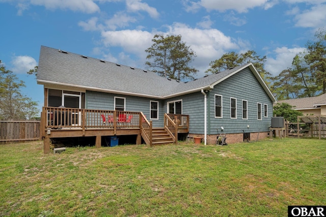 back of property featuring a wooden deck, central AC, a fenced backyard, a lawn, and roof with shingles