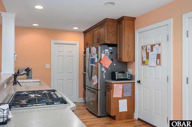 kitchen with light wood-style floors, light countertops, a sink, and appliances with stainless steel finishes
