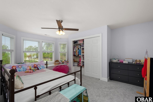 carpeted bedroom featuring a closet, baseboards, and ceiling fan