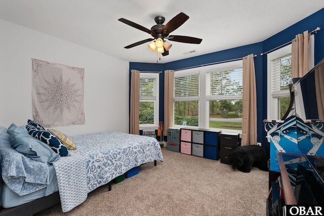bedroom with a ceiling fan, multiple windows, visible vents, and carpet floors