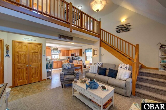 183 Lighthouse Rd Lot 3, Ocracoke, NC 27960 - living room with a towering ceiling, baseboards, stone finish floor, and stairway