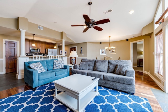 living area with lofted ceiling, ornate columns, visible vents, and dark wood-type flooring