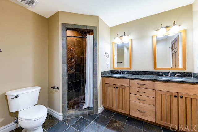 bathroom with double vanity, visible vents, toilet, a sink, and a shower stall