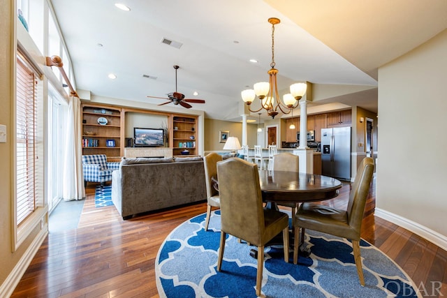 dining room featuring dark wood-style floors, vaulted ceiling, visible vents, and baseboards