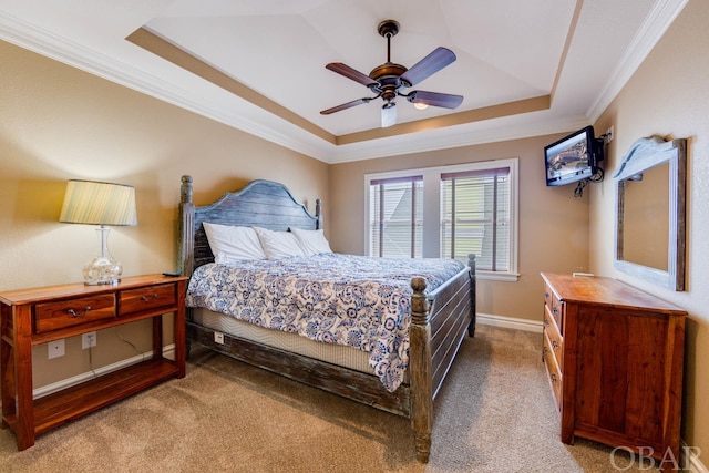 carpeted bedroom with a ceiling fan, a tray ceiling, crown molding, and baseboards