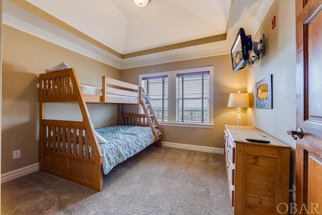 carpeted bedroom featuring ornamental molding, a tray ceiling, and baseboards