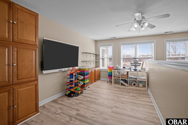 rec room with a wealth of natural light, light wood-type flooring, and baseboards