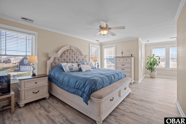 bedroom featuring light wood-type flooring, baseboards, visible vents, and crown molding