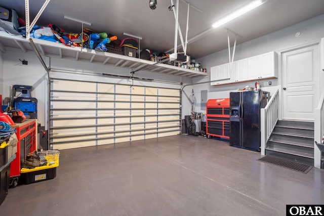 garage with black refrigerator with ice dispenser