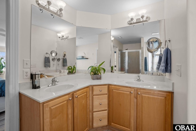 ensuite bathroom with double vanity, a stall shower, a sink, and ensuite bathroom