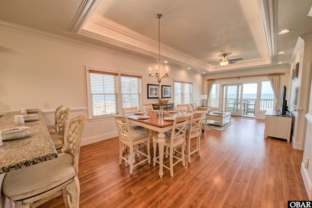 24252 Resort Rodanthe Dr Unit 1C, Rodanthe, NC 27968 - dining space featuring a tray ceiling, crown molding, a chandelier, light wood-style flooring, and ceiling fan