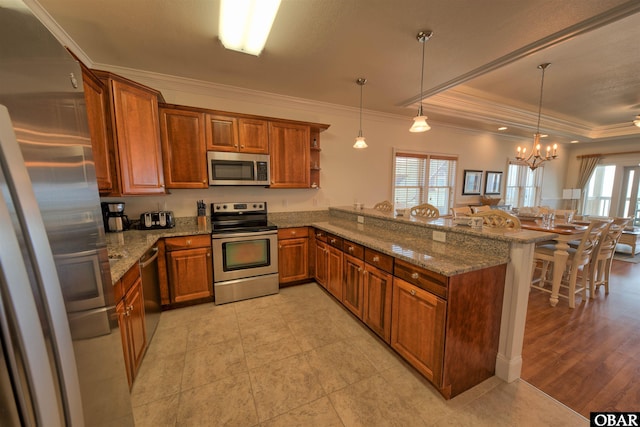 24252 Resort Rodanthe Dr Unit 1C, Rodanthe, NC 27968 - kitchen with appliances with stainless steel finishes, brown cabinets, ornamental molding, a peninsula, and a breakfast bar