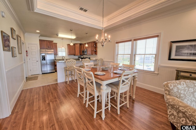 24252 Resort Rodanthe Dr Unit 1C, Rodanthe, NC 27968 - dining room with crown molding, healthy amount of natural light, light wood finished floors, wainscoting, and a raised ceiling