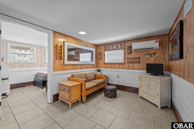 402 N Memorial Blvd Lot 3, Kill Devil Hills, NC 27948 - living room with a wall mounted air conditioner, wood walls, light tile patterned flooring, and a wainscoted wall