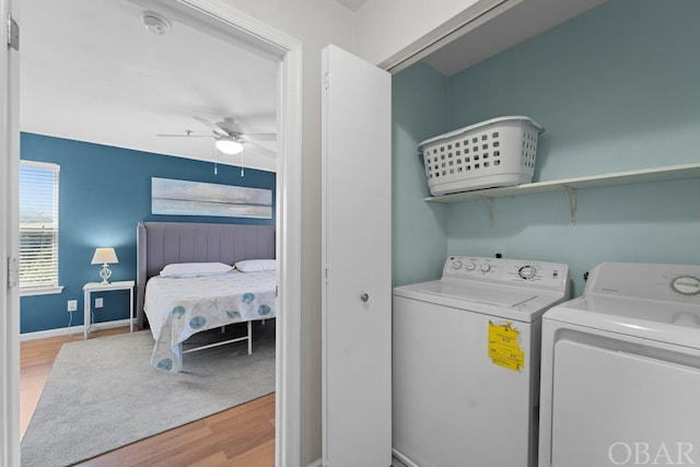 laundry room with laundry area, a ceiling fan, baseboards, light wood finished floors, and washer and clothes dryer