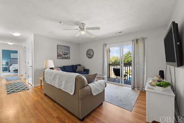 living area with a ceiling fan, baseboards, visible vents, and light wood finished floors