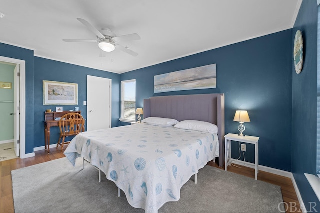 bedroom with connected bathroom, wood finished floors, a ceiling fan, baseboards, and a closet