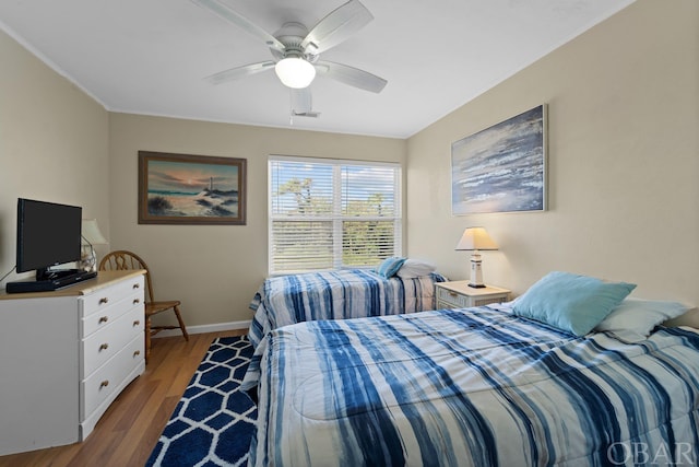 bedroom with light wood-style flooring, visible vents, a ceiling fan, baseboards, and crown molding