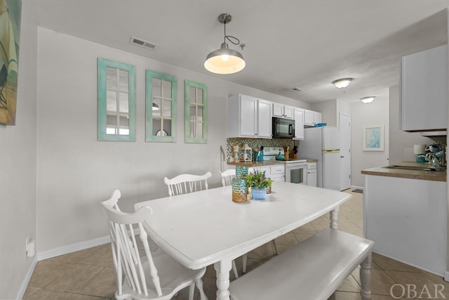 dining room featuring light tile patterned floors, baseboards, and visible vents