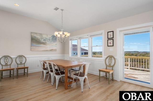 dining area featuring a chandelier, lofted ceiling, recessed lighting, wainscoting, and light wood-style floors