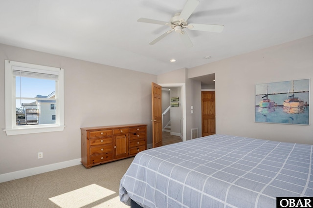 bedroom with visible vents, light carpet, baseboards, ceiling fan, and vaulted ceiling