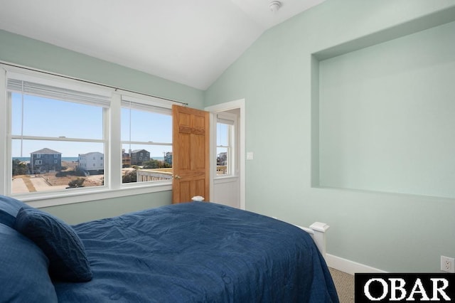 carpeted bedroom with baseboards and lofted ceiling