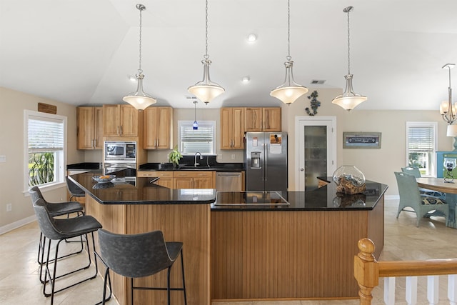 kitchen with stainless steel appliances, a large island, dark countertops, and decorative light fixtures