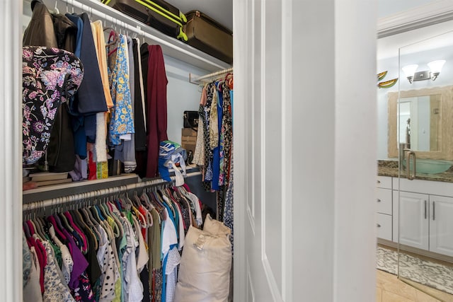 walk in closet with light tile patterned floors and a sink