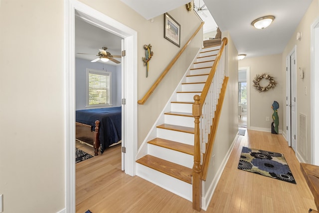 staircase featuring baseboards and wood finished floors