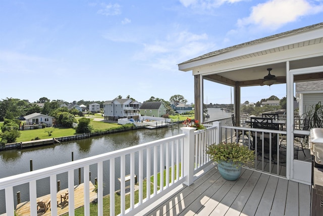 wooden deck featuring ceiling fan, a water view, and a residential view