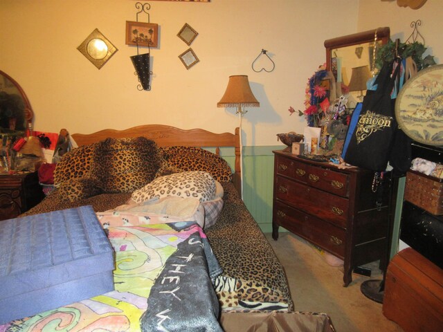 bedroom featuring wainscoting and light colored carpet