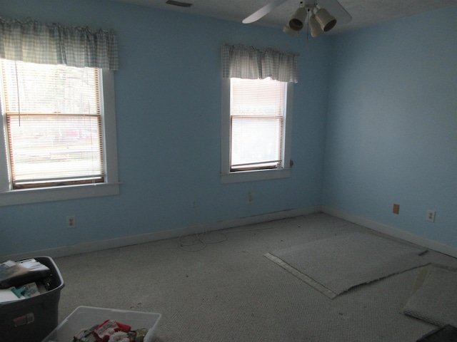 spare room featuring carpet floors, ceiling fan, and baseboards