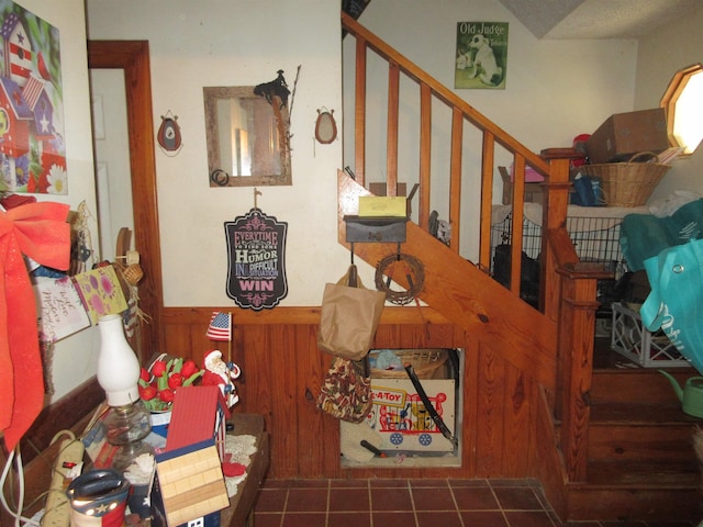 interior space featuring stairway and wainscoting