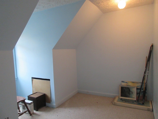 bonus room with lofted ceiling, light colored carpet, a textured ceiling, and baseboards