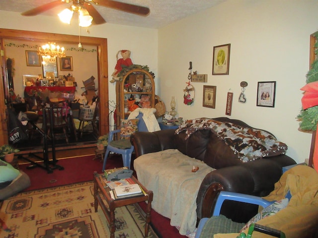 living area with a textured ceiling and ceiling fan with notable chandelier