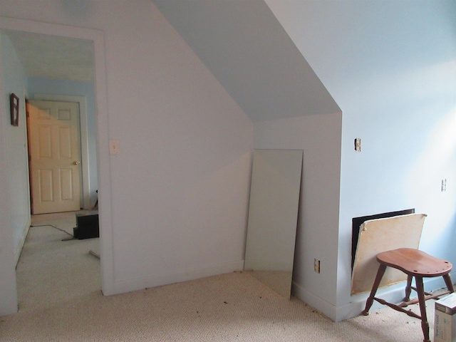 additional living space featuring lofted ceiling, baseboards, and light colored carpet