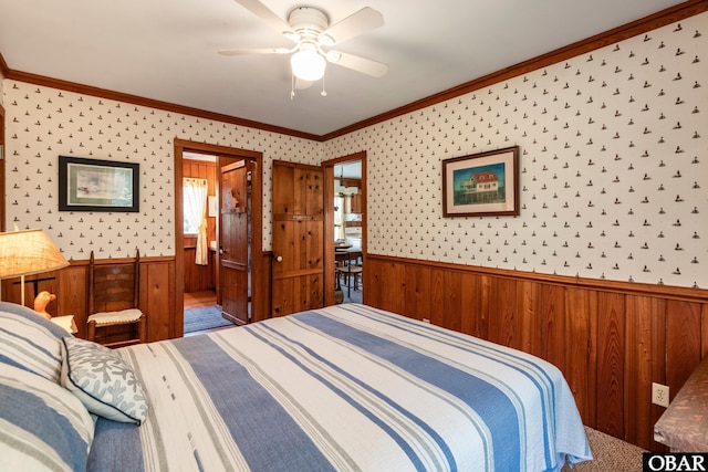 bedroom with wooden walls, wainscoting, and ornamental molding