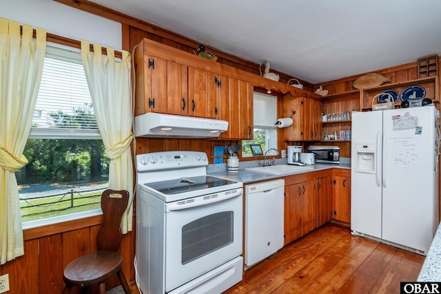 kitchen featuring open shelves, a sink, light countertops, under cabinet range hood, and white appliances