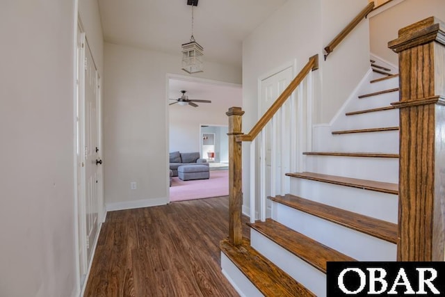 foyer with stairs, dark wood-style flooring, and baseboards