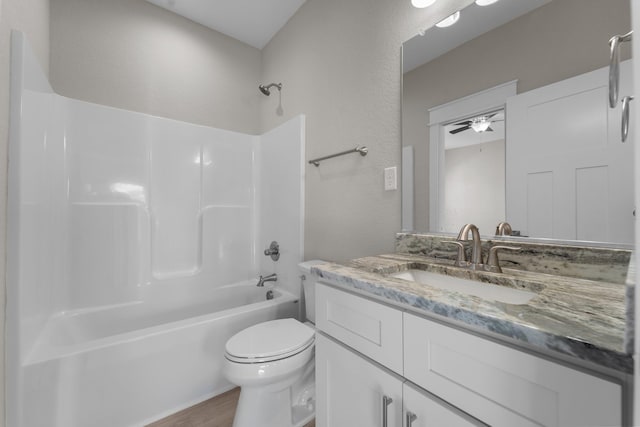 full bathroom with toilet, a ceiling fan, wood finished floors, shower / washtub combination, and vanity