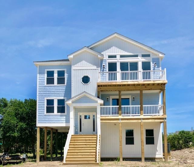 coastal home featuring a balcony, central AC, and a carport