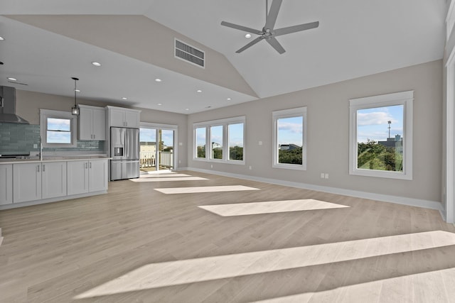 unfurnished living room with visible vents, high vaulted ceiling, recessed lighting, light wood-style floors, and baseboards