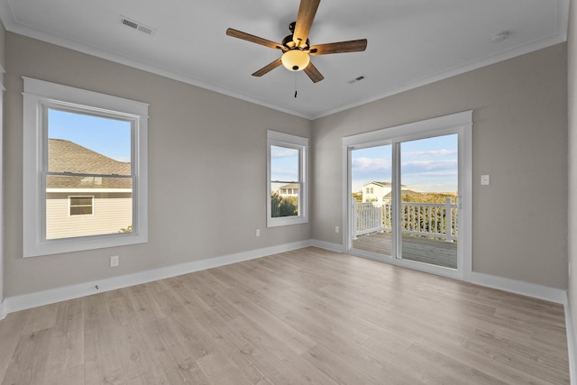 spare room featuring visible vents, baseboards, ornamental molding, and light wood finished floors